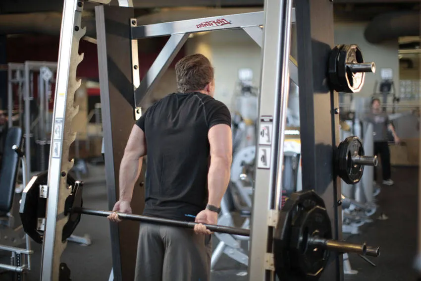 Smith Machine Behind the Back Shrug — end position