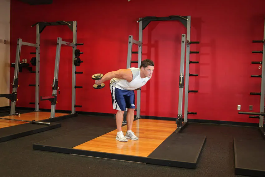 Standing Bent-Over Two-Arm Dumbbell Triceps Extension — end position