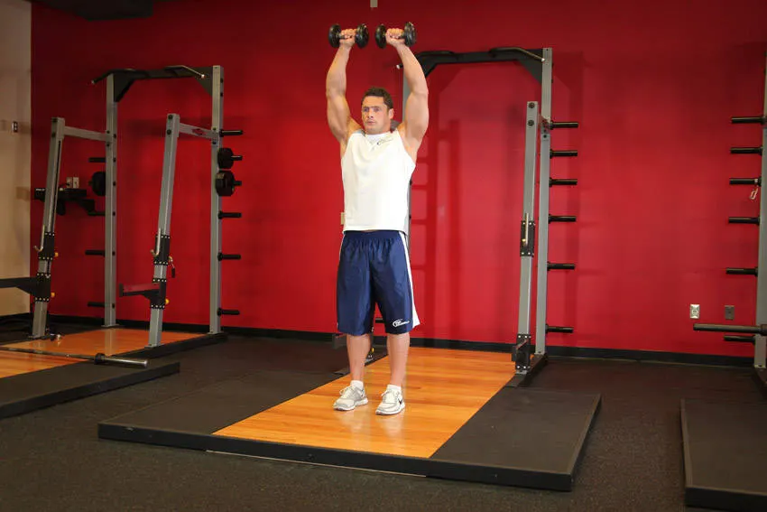 Standing Dumbbell Straight-Arm Front Delt Raise Above Head — end position