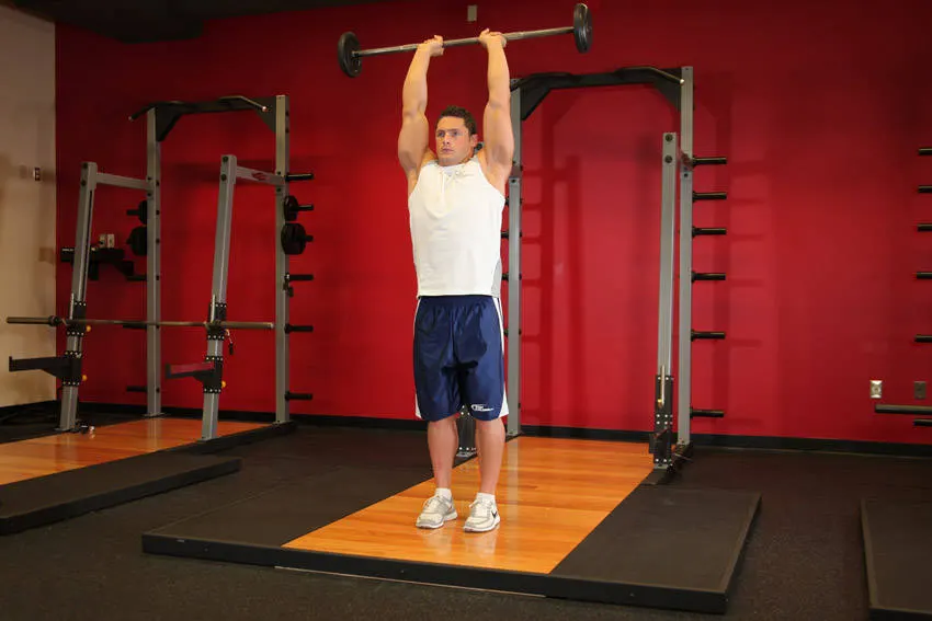 Standing Overhead Barbell Triceps Extension — end position